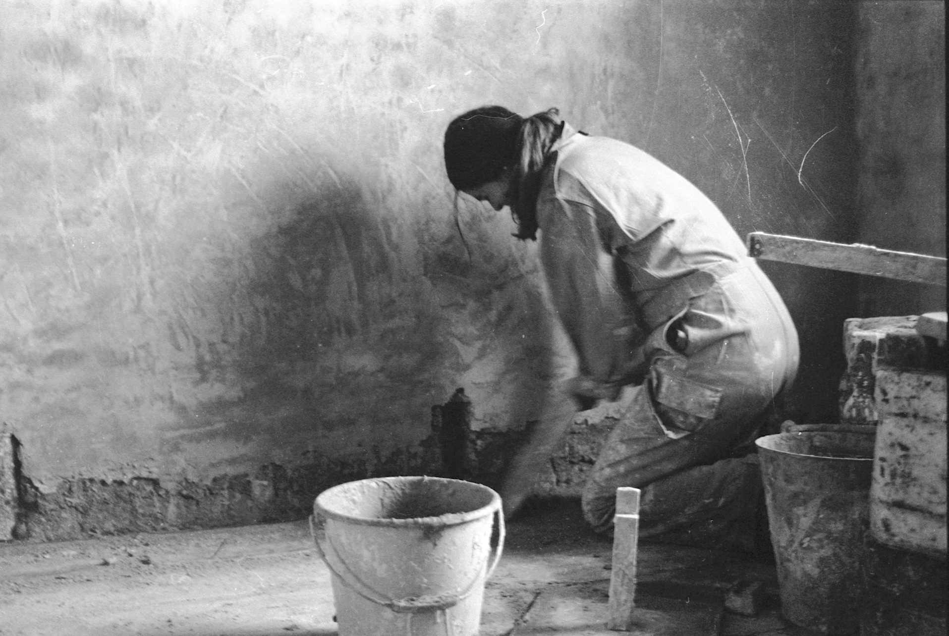 Woman squatter plastering living room
